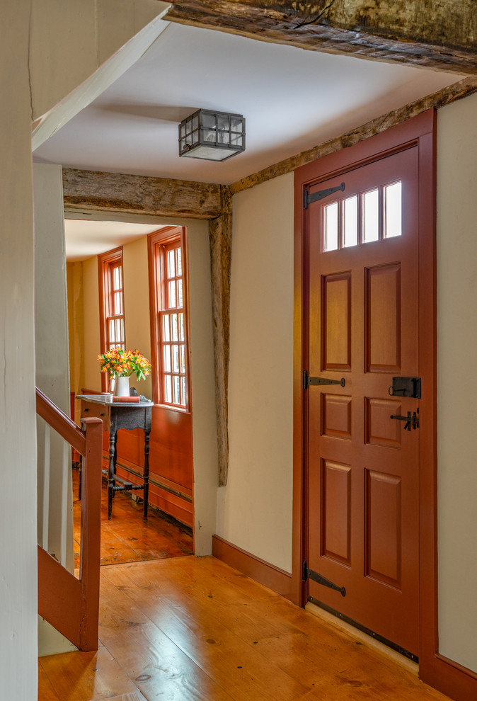Design ideas for a mid-sized country front door in Boston with white walls, medium hardwood floors, a single front door and a red front door.