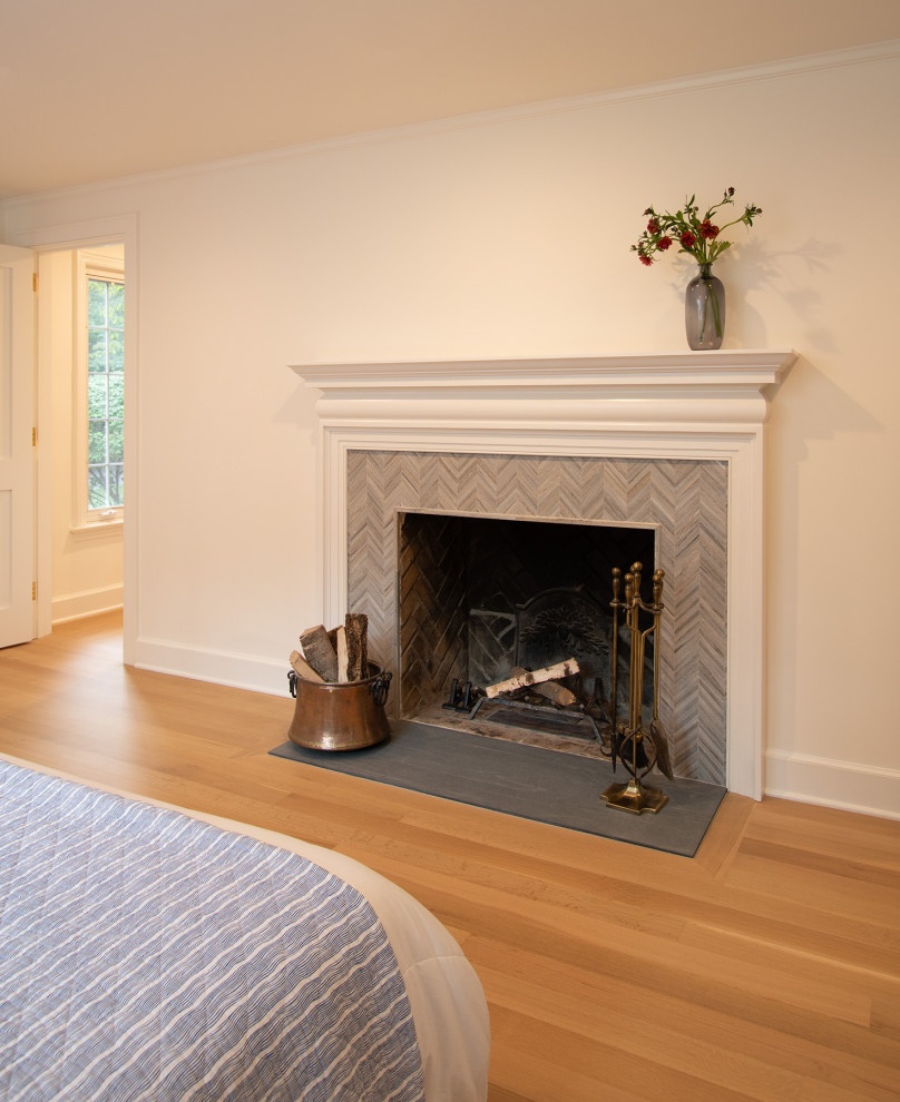 Foto de dormitorio clásico renovado grande con suelo de madera clara, todas las chimeneas, marco de chimenea de baldosas y/o azulejos y suelo beige