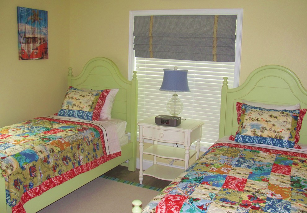 This is an example of a small beach style guest bedroom in Orlando with yellow walls, laminate floors and no fireplace.