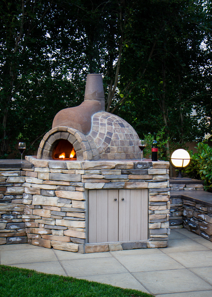 This is an example of a rustic full sun backyard concrete paver landscaping.