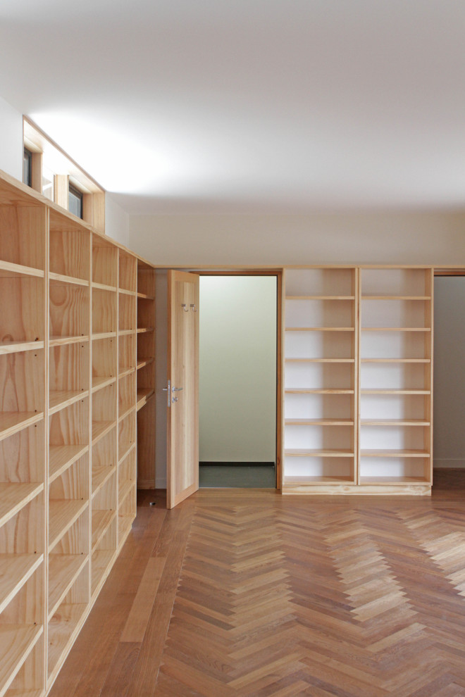 Aménagement d'un très grand bureau campagne avec une bibliothèque ou un coin lecture, un mur beige et un sol en bois brun.