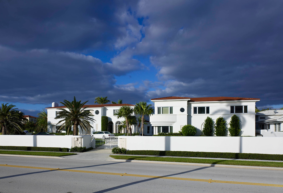 Photo of a large mediterranean two-storey white exterior in Miami with a hip roof.