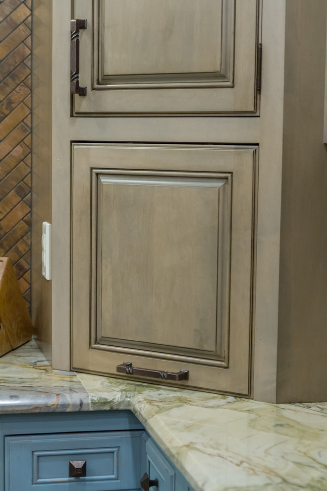 Example of a mountain style kitchen design with stainless steel appliances and an island