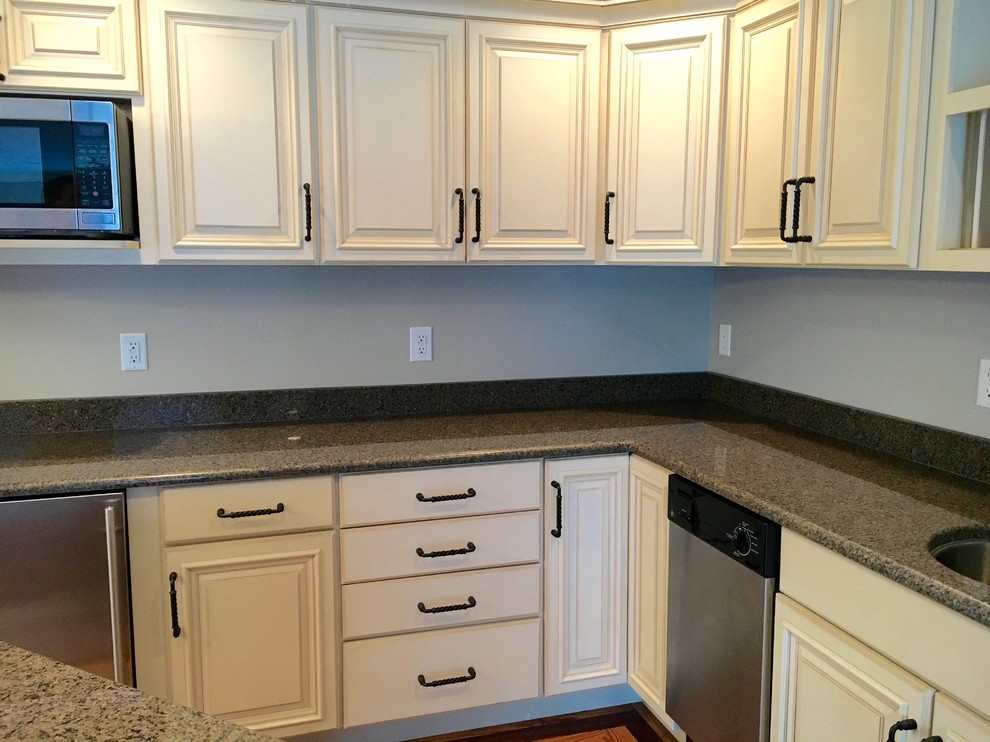 Inspiration for a small transitional l-shaped dark wood floor home design remodel in Cincinnati with an undermount sink, raised-panel cabinets, white cabinets, granite countertops, gray backsplash, stainless steel appliances and an island