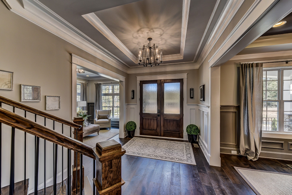 Large transitional entry hall in Charlotte with dark hardwood floors, a double front door, a dark wood front door, recessed and decorative wall panelling.
