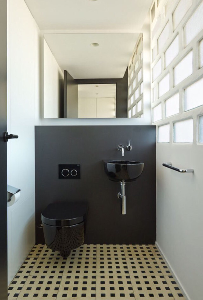 Foto de aseo contemporáneo pequeño con sanitario de pared, baldosas y/o azulejos negros, paredes negras, suelo de baldosas de cerámica, lavabo suspendido y suelo multicolor