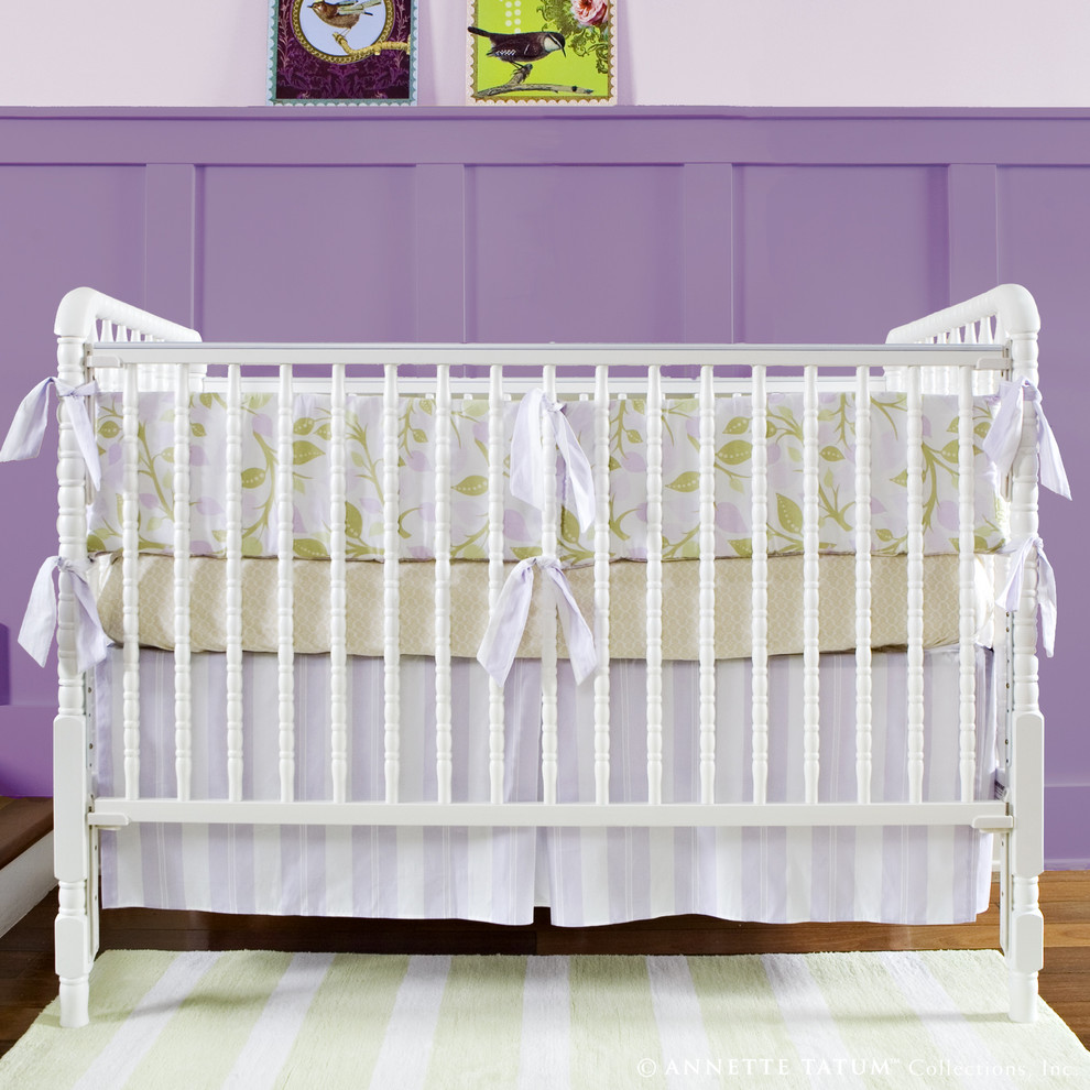 Diseño de habitación de bebé niña actual con paredes púrpuras y suelo de madera en tonos medios