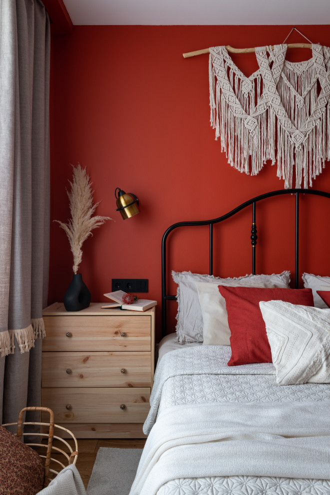 Photo of a small master bedroom in Moscow with red walls, medium hardwood flooring and a feature wall.