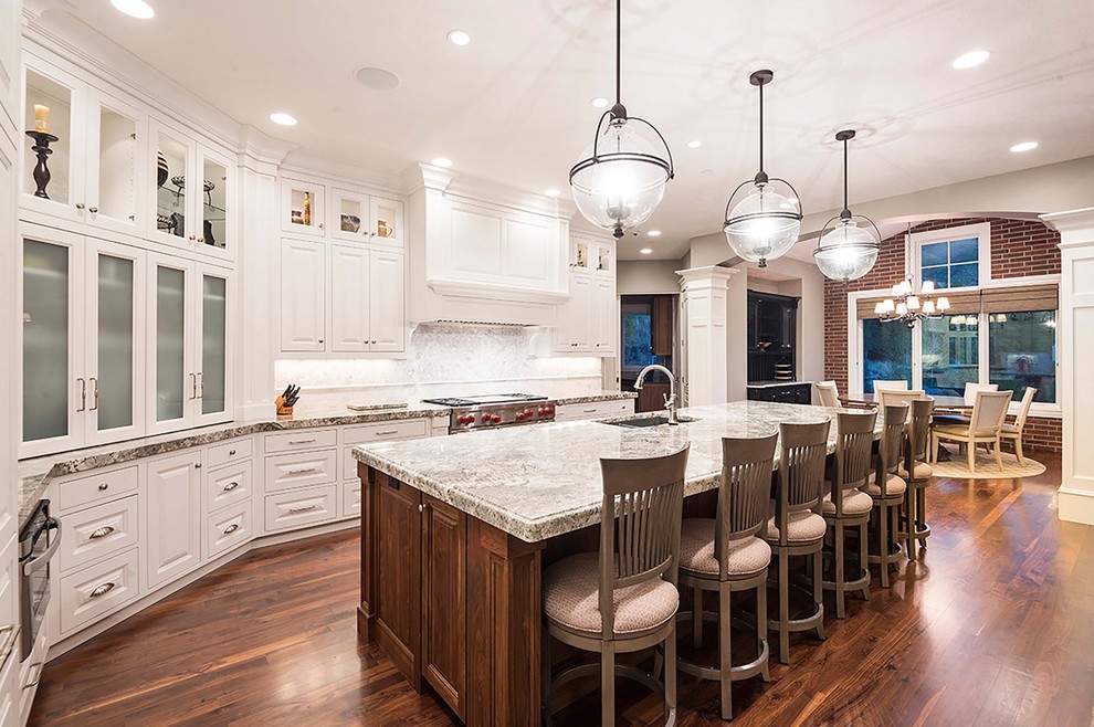Inspiration for a large transitional l-shaped open plan kitchen in Salt Lake City with an undermount sink, raised-panel cabinets, white cabinets, quartzite benchtops, multi-coloured splashback, mosaic tile splashback, stainless steel appliances, dark hardwood floors, with island and brown floor.