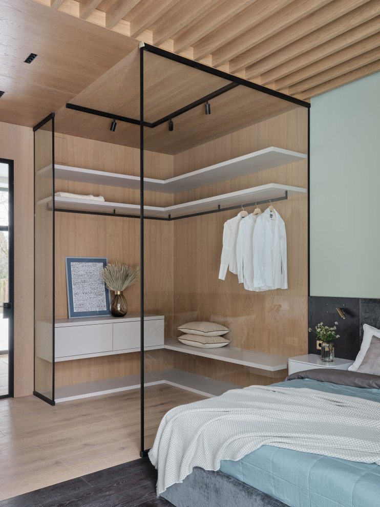 На фото: большая хозяйская спальня в стиле лофт с деревянным потолком и панелями на части стены с