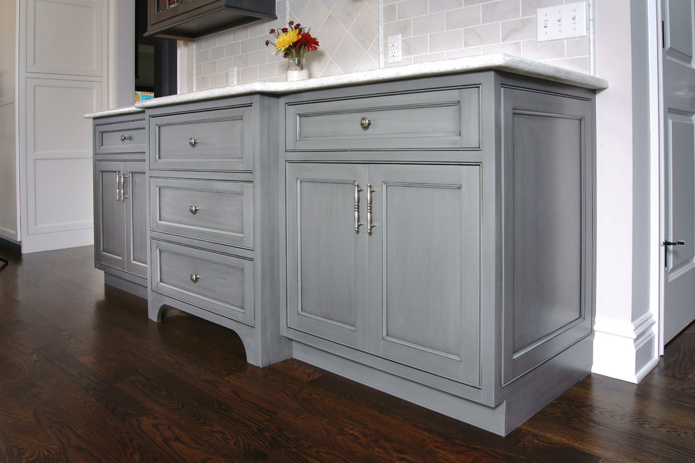 Eat-in kitchen - large transitional u-shaped dark wood floor eat-in kitchen idea in New York with white cabinets, white backsplash, an island, a farmhouse sink, beaded inset cabinets, subway tile backsplash and paneled appliances