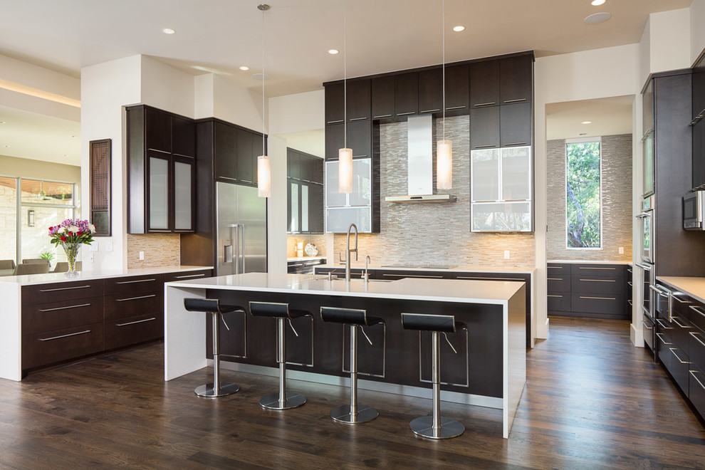 Inspiration for a contemporary u-shaped kitchen in Austin with flat-panel cabinets, beige splashback, matchstick tile splashback, stainless steel appliances, dark hardwood floors, with island and dark wood cabinets.