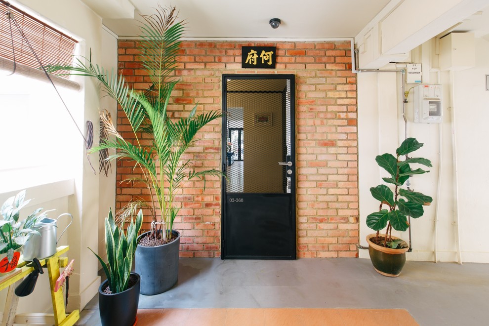 This is an example of an eclectic entryway in Singapore with white walls, concrete floors, a single front door, a black front door and grey floor.