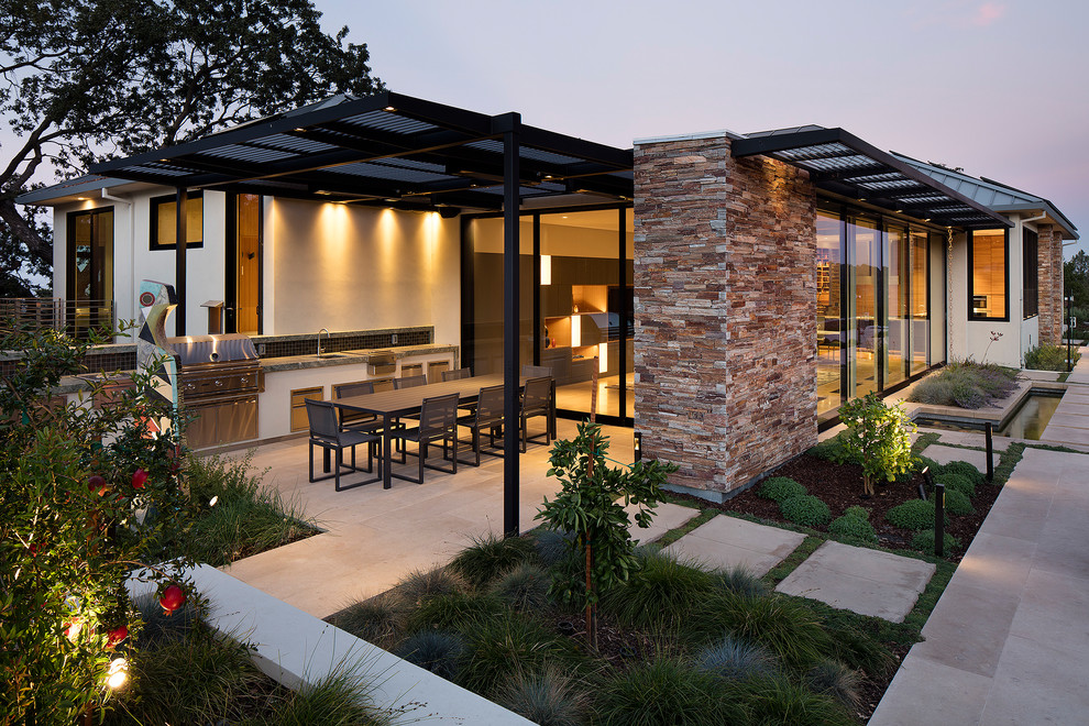 Inspiration for a mid-sized contemporary backyard patio in San Francisco with an outdoor kitchen, natural stone pavers and a pergola.