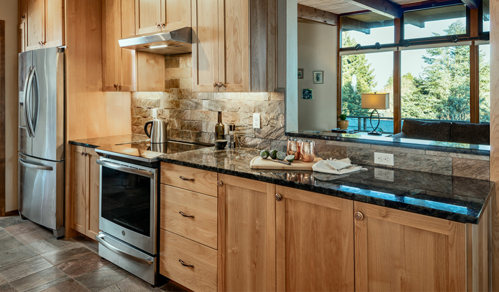 This is an example of a small country galley eat-in kitchen in Other with a farmhouse sink, shaker cabinets, light wood cabinets, granite benchtops, slate splashback, stainless steel appliances, slate floors, no island, blue benchtop and wood.