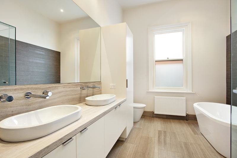Mid-sized transitional bathroom in Melbourne with flat-panel cabinets, white cabinets, a freestanding tub, a corner shower, a two-piece toilet, white walls and a hinged shower door.