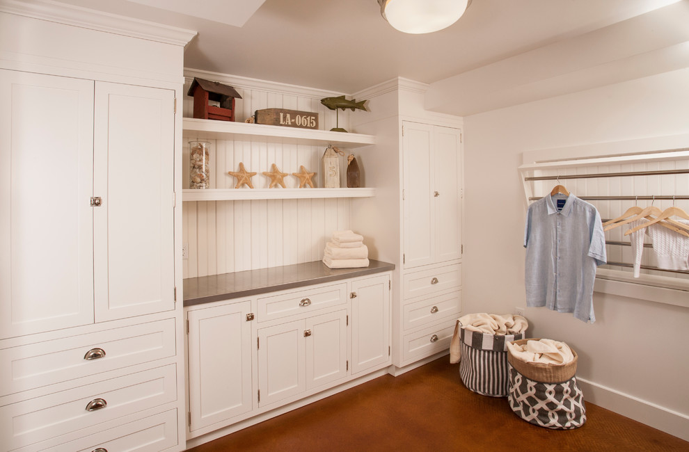 Mid-sized transitional dedicated laundry room in Seattle with shaker cabinets, white cabinets, zinc benchtops, white walls, concrete floors and a side-by-side washer and dryer.