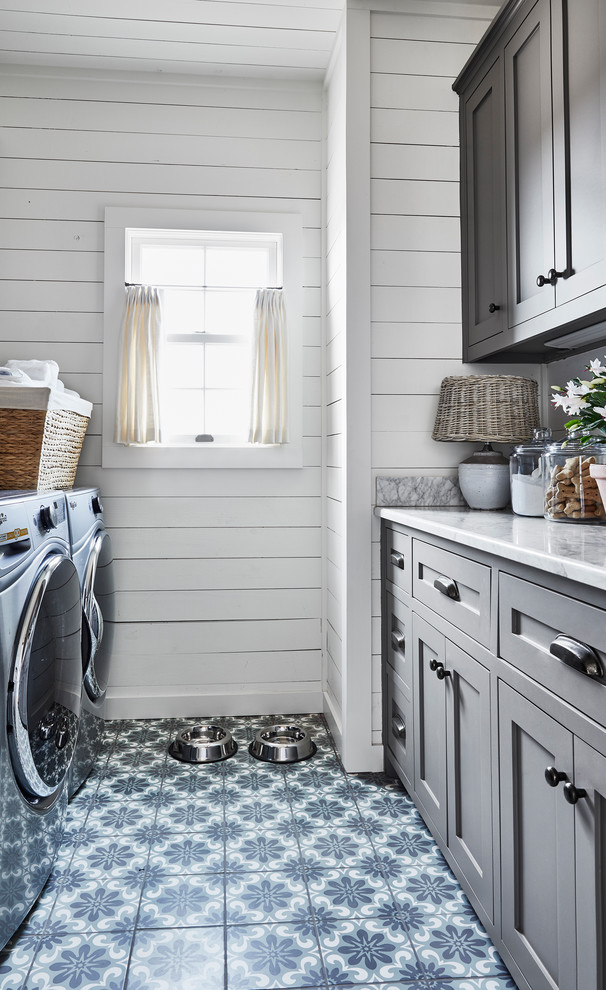 This is an example of a mid-sized beach style laundry room in Dallas with shaker cabinets, grey cabinets, quartzite benchtops, white walls, ceramic floors, a side-by-side washer and dryer and multi-coloured floor.