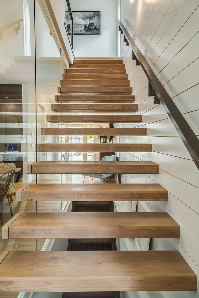 Design ideas for a mid-sized country wood floating staircase in Calgary with open risers and wood railing.