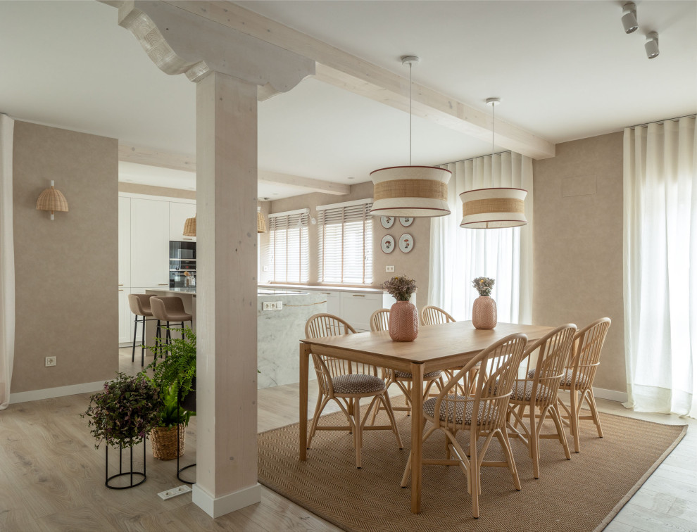 This is an example of a large transitional open plan dining in Other with beige walls, laminate floors, a standard fireplace, exposed beam and wallpaper.