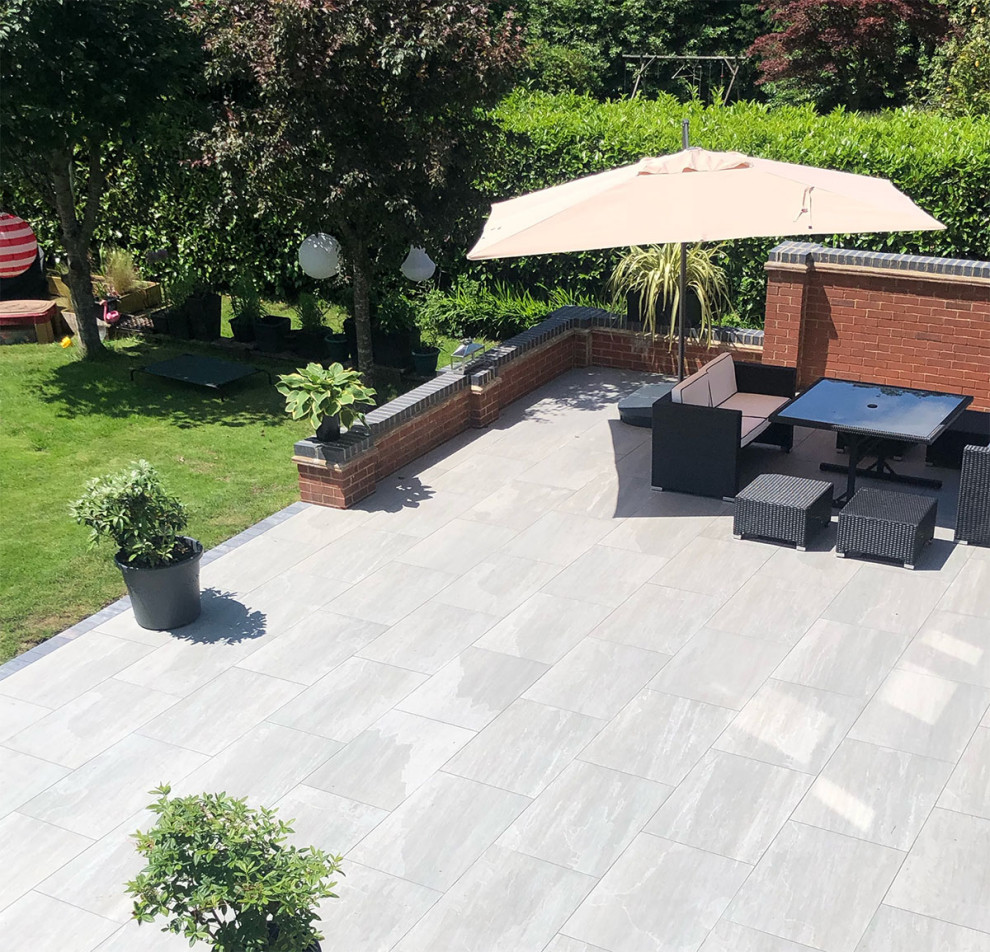 Large contemporary backyard patio in Essex with tile.