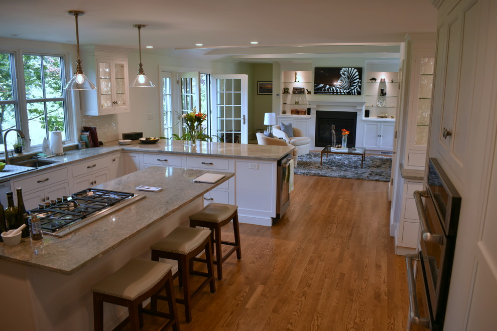 Design ideas for a large transitional open plan kitchen in Boston with an undermount sink, beaded inset cabinets, white cabinets, granite benchtops, white splashback, ceramic splashback, stainless steel appliances, medium hardwood floors, a peninsula, beige floor and beige benchtop.