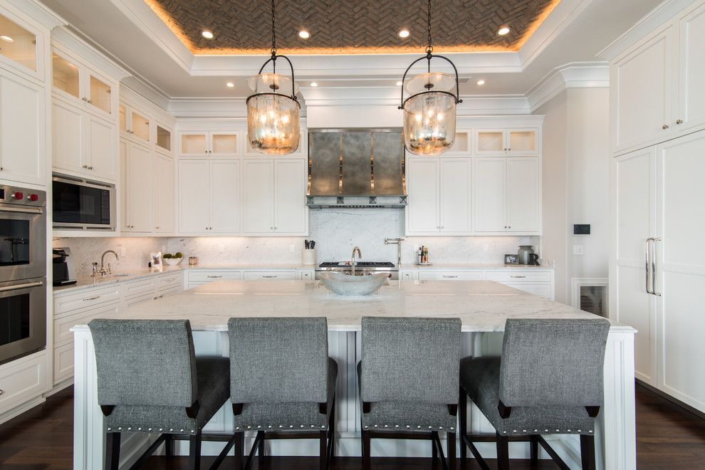 Example of a transitional dark wood floor kitchen design in Charlotte with shaker cabinets, white cabinets, white backsplash, stone slab backsplash, paneled appliances and an island