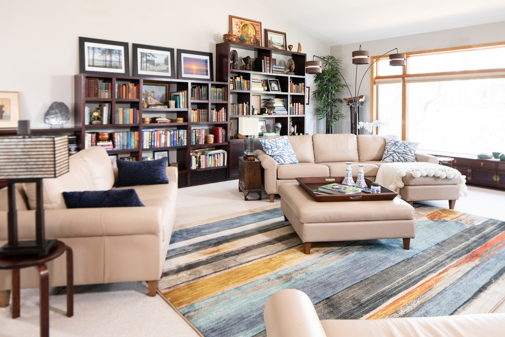 Photo of a mid-sized transitional enclosed living room in Milwaukee with a library, grey walls, carpet, grey floor, a two-sided fireplace and a tile fireplace surround.