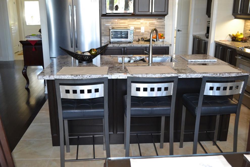 Inspiration for a timeless eat-in kitchen remodel in Toronto with an undermount sink, shaker cabinets, dark wood cabinets, quartz countertops, glass tile backsplash, stainless steel appliances and an island