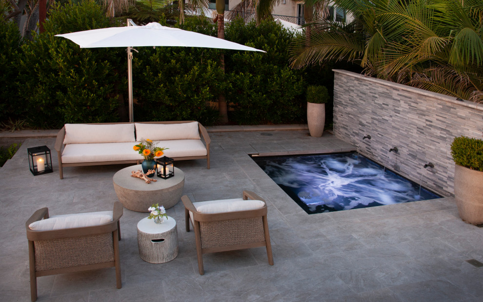 This is an example of a medium sized coastal back rectangular natural swimming pool in San Diego with with pool landscaping and tiled flooring.