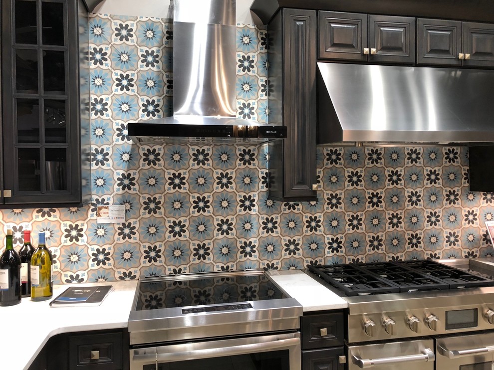 Mid-sized transitional kitchen photo with raised-panel cabinets, quartz countertops, blue backsplash, cement tile backsplash, dark wood cabinets and stainless steel appliances