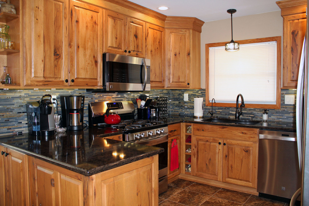 Mid-sized mountain style u-shaped kitchen photo with raised-panel cabinets, medium tone wood cabinets, quartz countertops, stone tile backsplash and stainless steel appliances