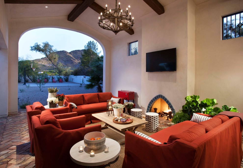 Photo of a mediterranean patio in Phoenix with brick pavers and with fireplace.