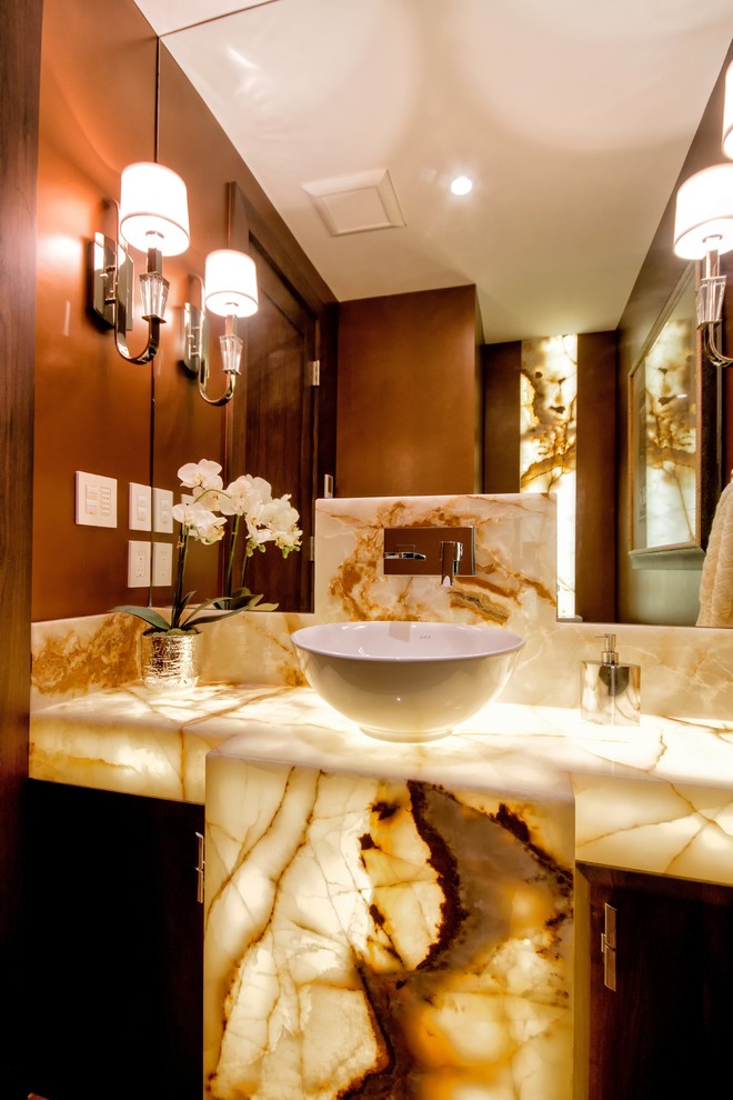 Mid-sized transitional powder room in Vancouver with a vessel sink, flat-panel cabinets, dark wood cabinets, onyx benchtops, brown walls and beige benchtops.
