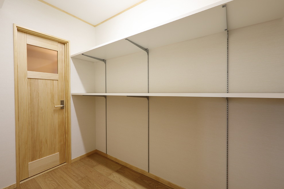 This is an example of a large walk-in wardrobe in Other with plywood floors and beige floor.