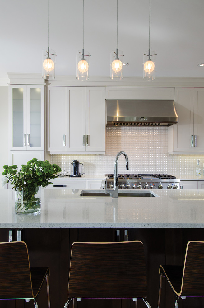 Eat-in kitchen - large transitional l-shaped medium tone wood floor eat-in kitchen idea with an undermount sink, recessed-panel cabinets, white cabinets, quartz countertops, white backsplash, porcelain backsplash, stainless steel appliances and an island