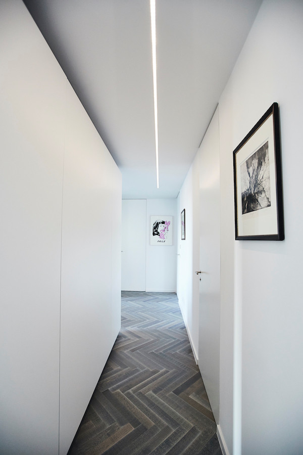Стильный дизайн: маленький коридор в современном стиле с белыми стенами, деревянным полом и серым полом для на участке и в саду - последний тренд