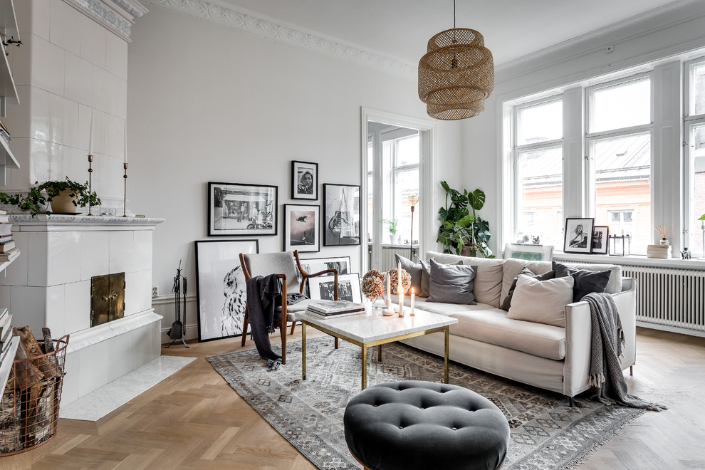 Mid-sized scandinavian formal open concept living room in Stockholm with white walls, medium hardwood floors, a corner fireplace and a tile fireplace surround.