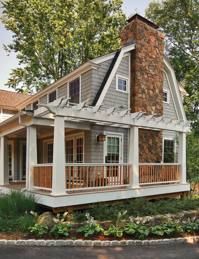 Design ideas for a mid-sized traditional two-storey exterior in New York with wood siding and a gambrel roof.