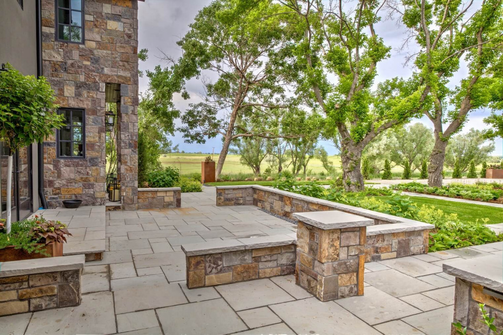 Large country courtyard garden in Denver with natural stone pavers.