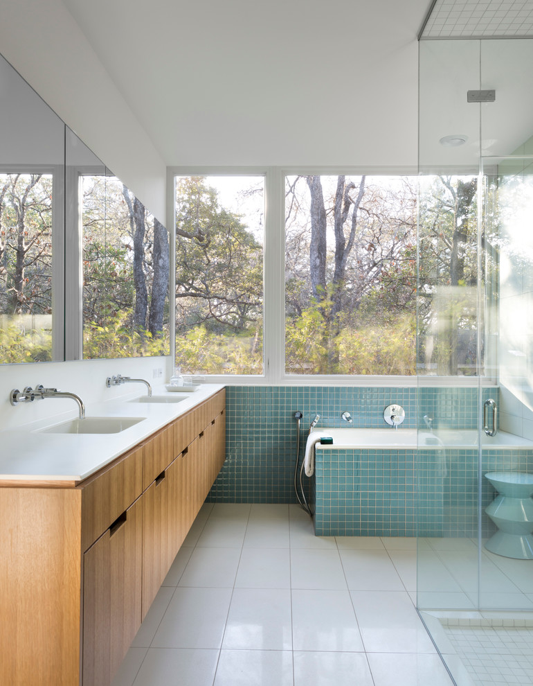 Design ideas for a midcentury bathroom in Austin with an undermount sink, a drop-in tub, blue tile and white walls.