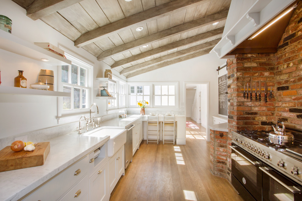 Design ideas for a country kitchen in Los Angeles with a farmhouse sink, shaker cabinets, white cabinets, black appliances, medium hardwood floors and no island.