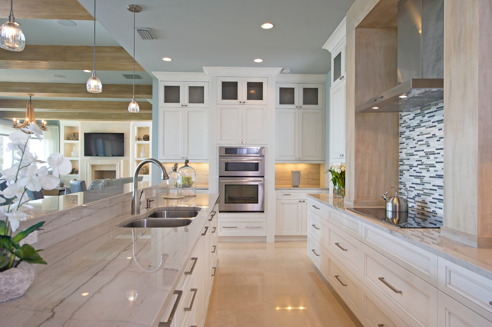Photo of a beach style u-shaped eat-in kitchen in Orlando with recessed-panel cabinets, white cabinets, white splashback, matchstick tile splashback and panelled appliances.