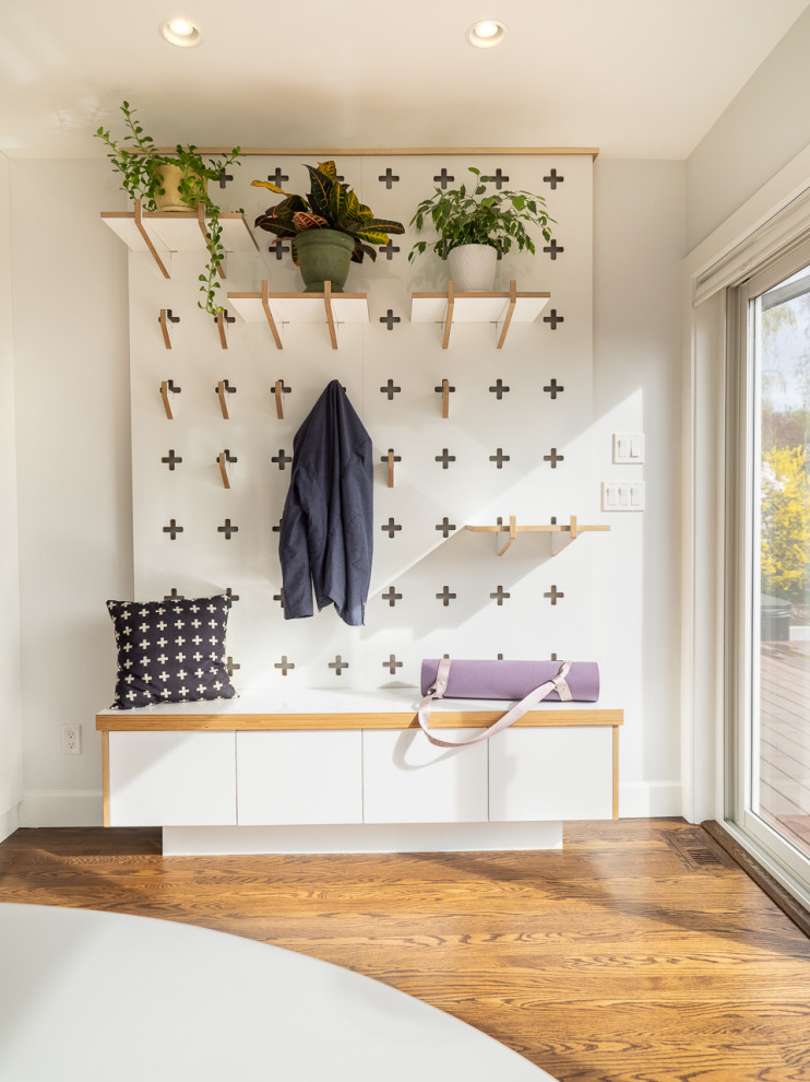Example of a small transitional light wood floor and brown floor hallway design in Vancouver with white walls