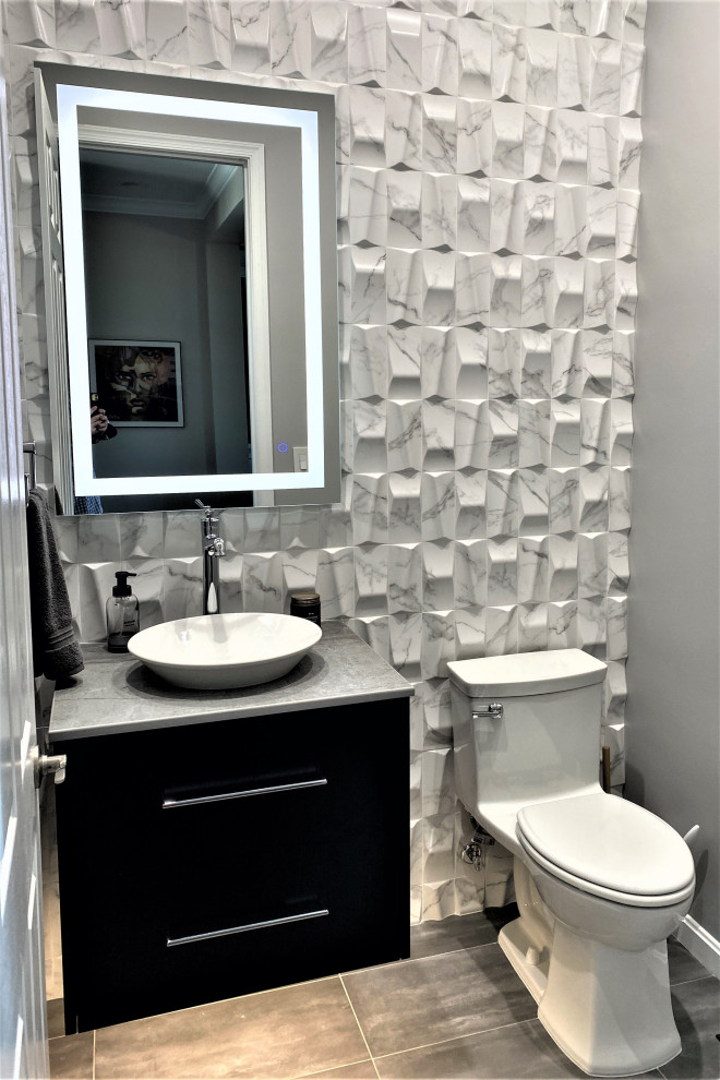 Стильный дизайн: маленький туалет в стиле неоклассика (современная классика) с плоскими фасадами, черными фасадами, унитазом-моноблоком, черно-белой плиткой, керамической плиткой, серыми стенами, полом из керамогранита, настольной раковиной, столешницей из искусственного кварца, серым полом, серой столешницей и подвесной тумбой для на участке и в саду - последний тренд