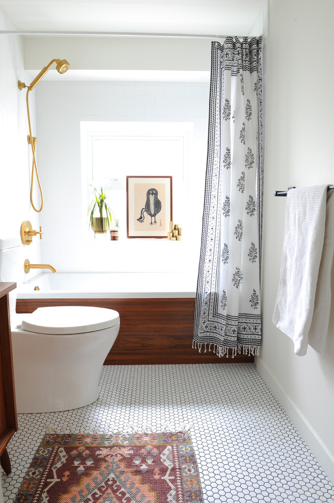 This is an example of a small midcentury master bathroom in Vancouver with flat-panel cabinets, medium wood cabinets, an alcove tub, a shower/bathtub combo, a two-piece toilet, white tile, ceramic tile, white walls, porcelain floors, wood benchtops, white floor and a shower curtain.