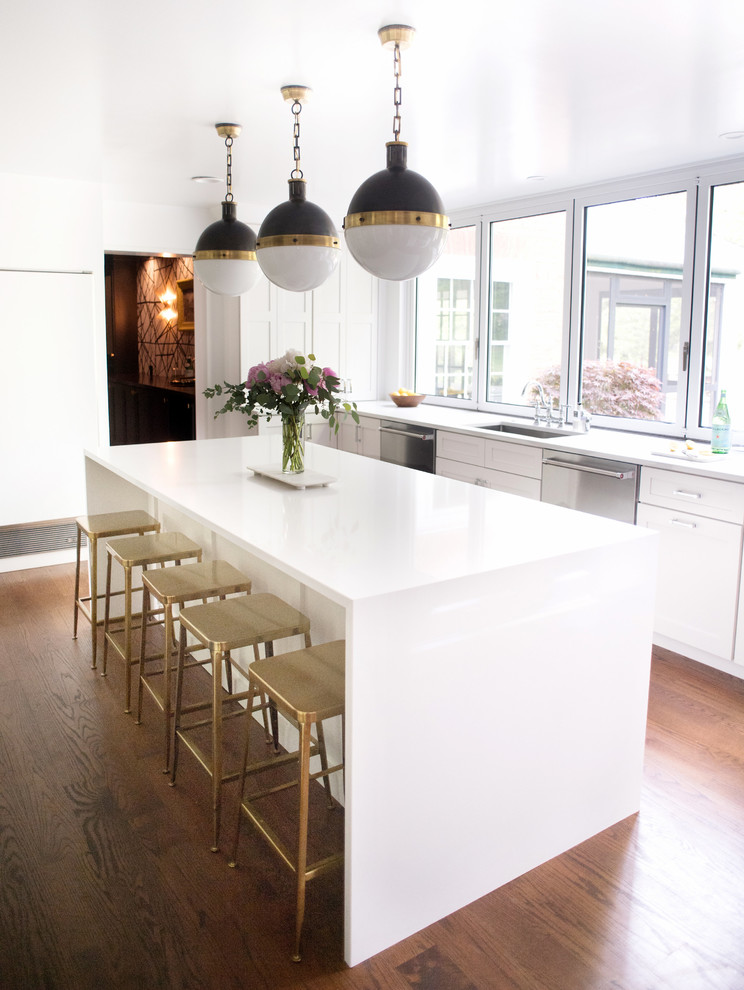 Inspiration for a transitional dark wood floor and brown floor enclosed kitchen remodel with an undermount sink, shaker cabinets, white cabinets, quartz countertops, white backsplash, stone slab backsplash, stainless steel appliances and an island