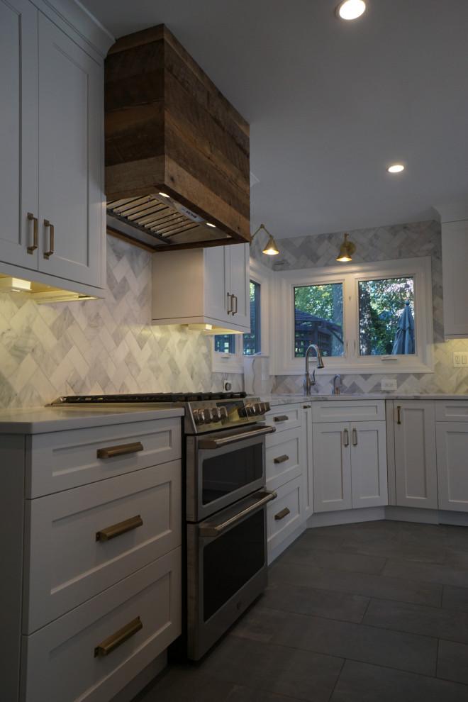 Photo of a small country l-shaped eat-in kitchen in DC Metro with an undermount sink, recessed-panel cabinets, white cabinets, quartz benchtops, white splashback, marble splashback, stainless steel appliances, porcelain floors, with island, grey floor and white benchtop.