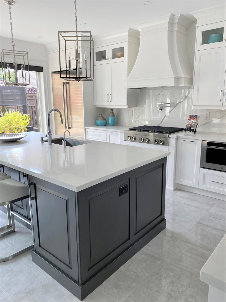 Example of a large transitional l-shaped porcelain tile and white floor open concept kitchen design in Toronto with an undermount sink, recessed-panel cabinets, white cabinets, quartz countertops, white backsplash, stone slab backsplash, stainless steel appliances, an island and white countertops