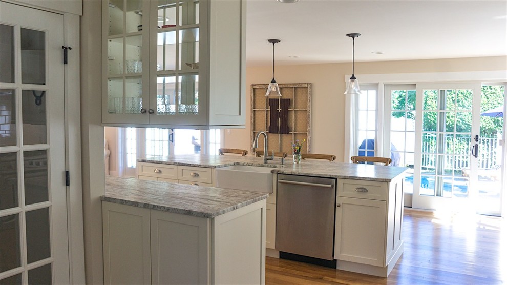 Open concept kitchen - mid-sized transitional galley dark wood floor and brown floor open concept kitchen idea in Boston with a farmhouse sink, shaker cabinets, white cabinets, granite countertops, white backsplash, subway tile backsplash, stainless steel appliances and an island